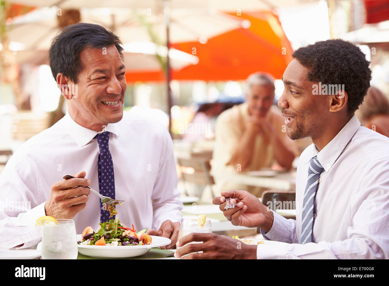 Deux hommes d'avoir rencontre en restaurant en plein air Banque D'Images