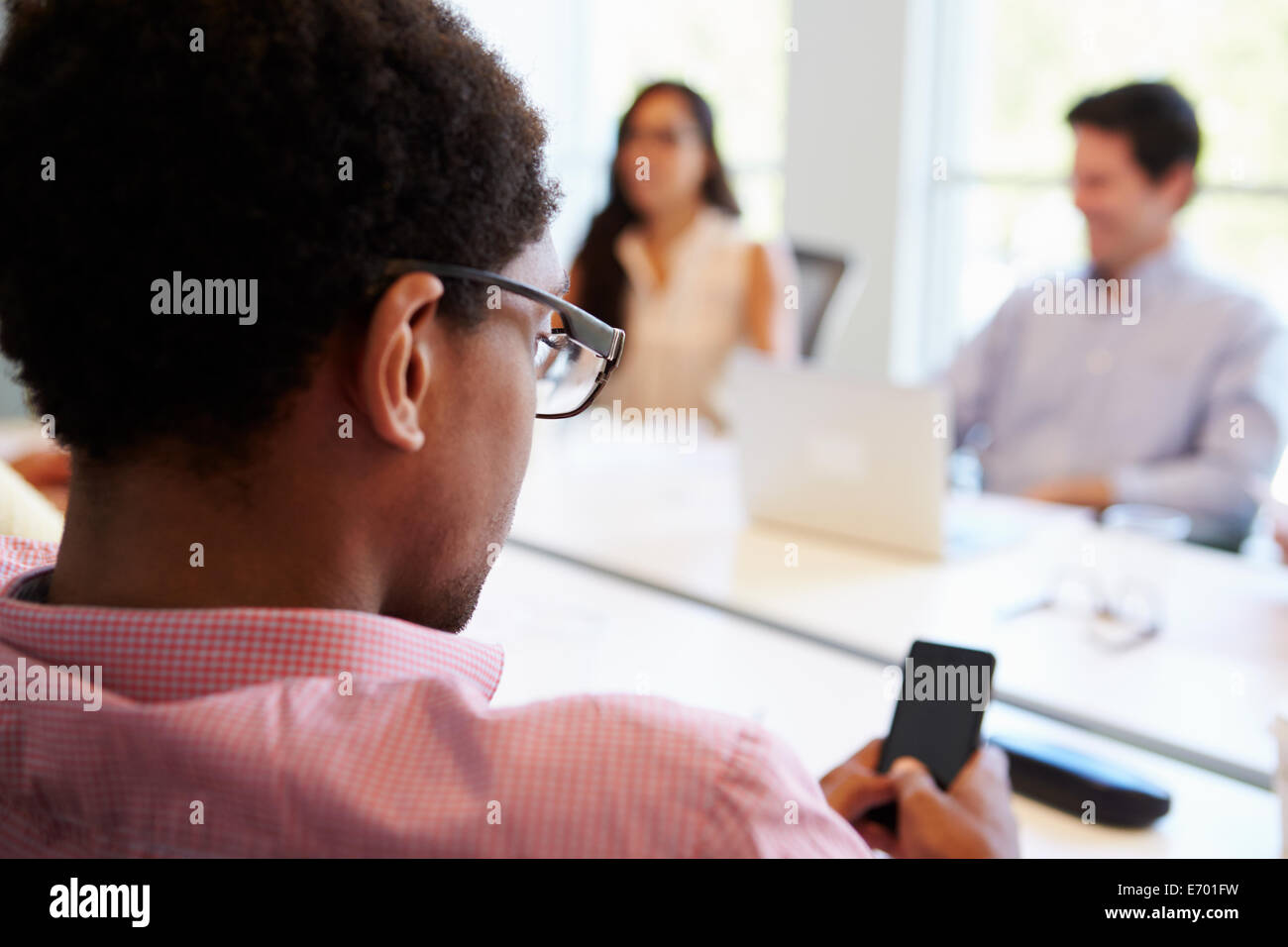 Concepteur à l'aide de téléphone mobile au cours de réunion Banque D'Images