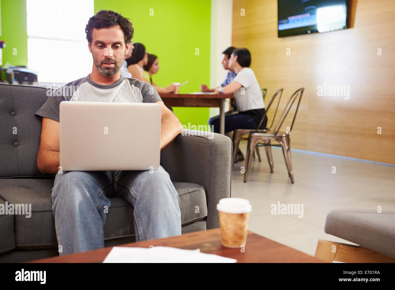 Homme assis sur un canapé et travaillant en Design Studio Banque D'Images