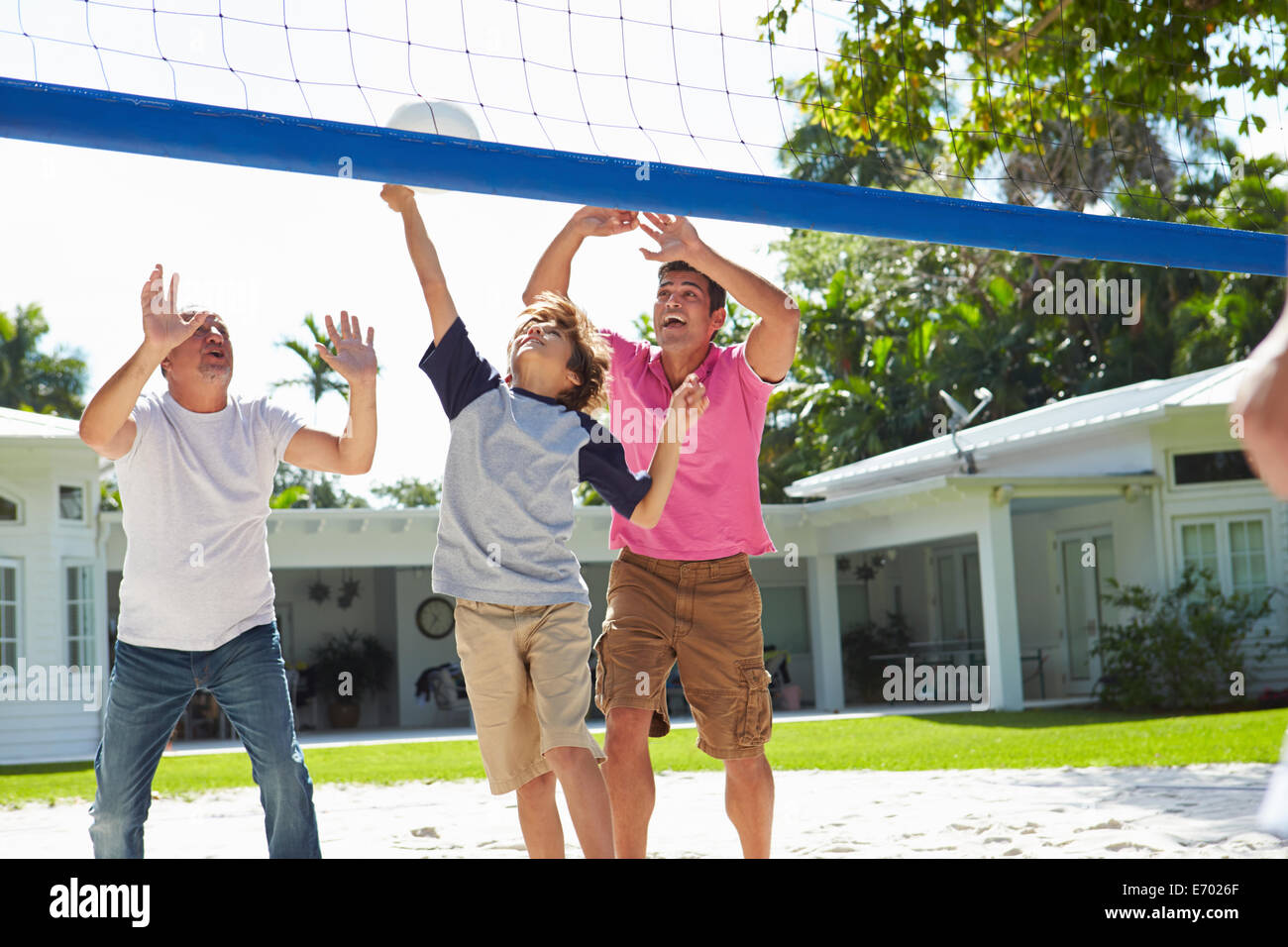 Homme Multi Generation Family Playing Volleyball dans jardin Banque D'Images