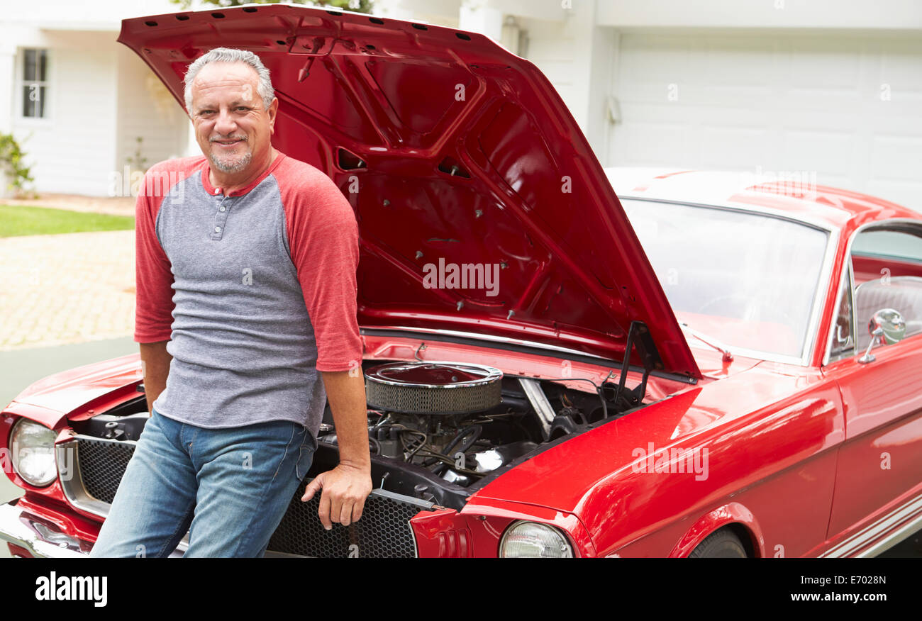 Homme supérieurs à la retraite travaillant sur voiture classique restauré Banque D'Images