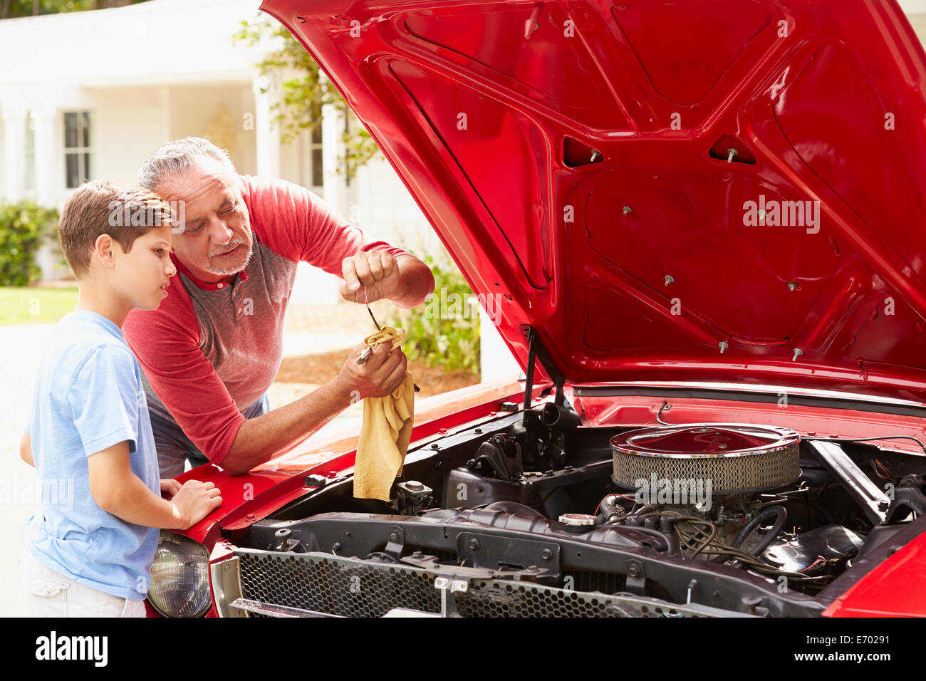 Grand-père et petit-fils travaillant sur voiture classique restauré Banque D'Images