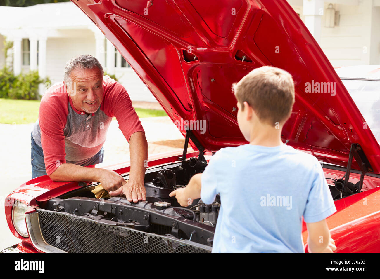 Grand-père et petit-fils travaillant sur voiture classique restauré Banque D'Images