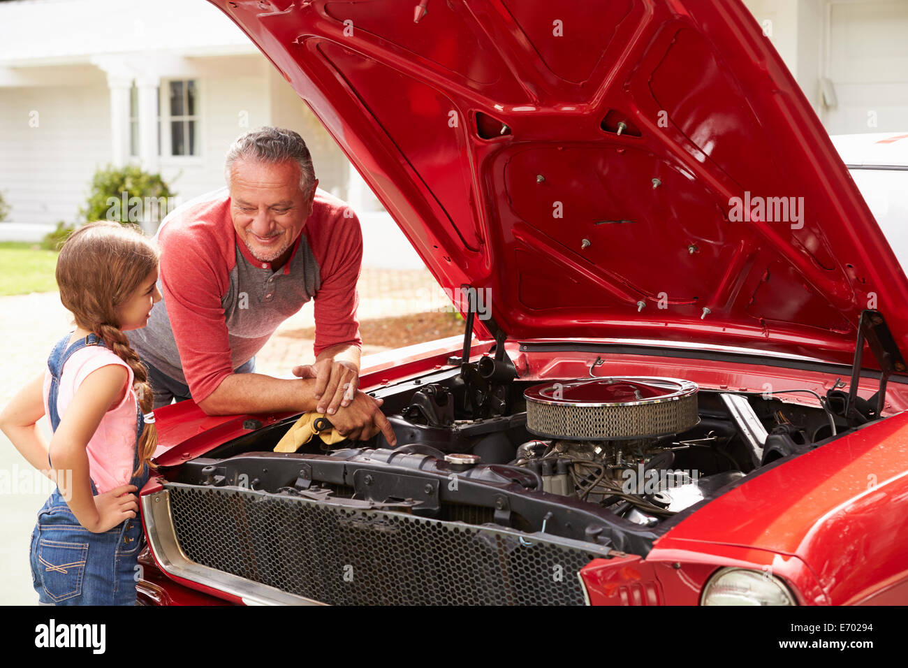 Grand-père et sa petite-fille travailler sur voiture classique restauré Banque D'Images