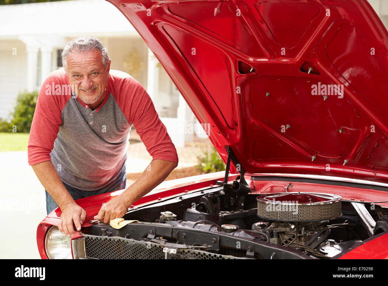 Homme supérieurs à la retraite travaillant sur voiture classique restauré Banque D'Images