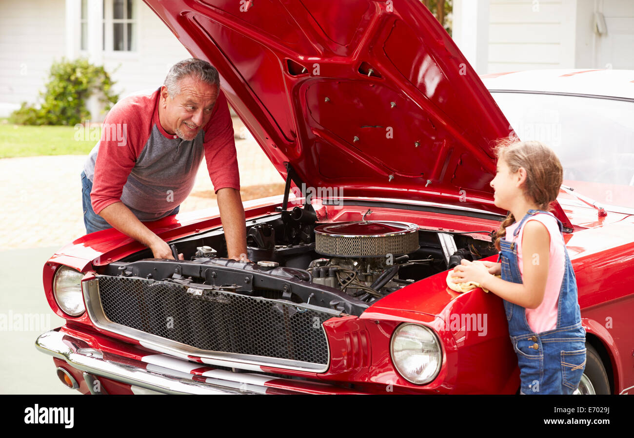 Grand-père et petite-fille de travailler sur voiture classique Banque D'Images