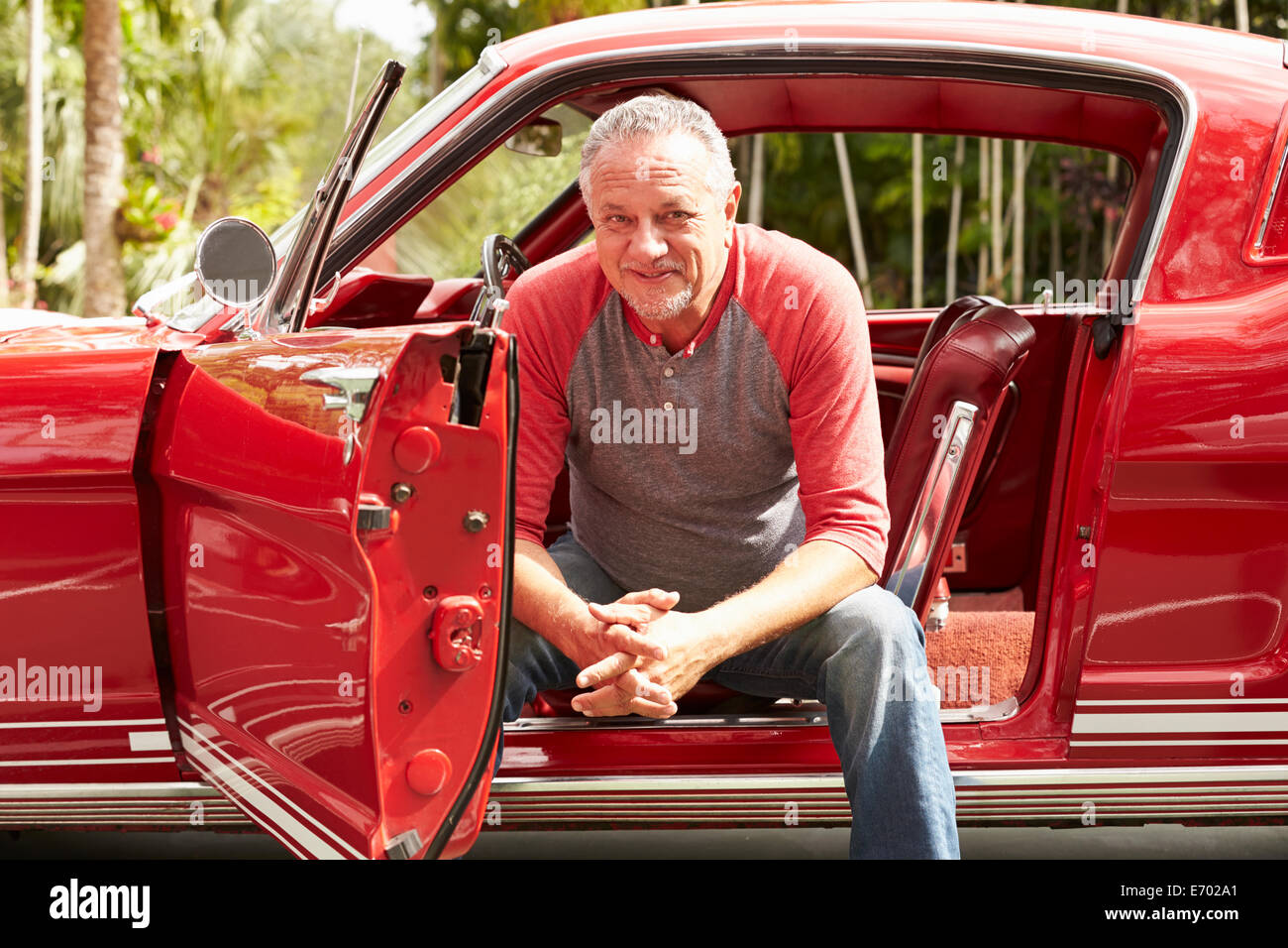 Cadre supérieur retraité homme assis en voiture classique restauré Banque D'Images