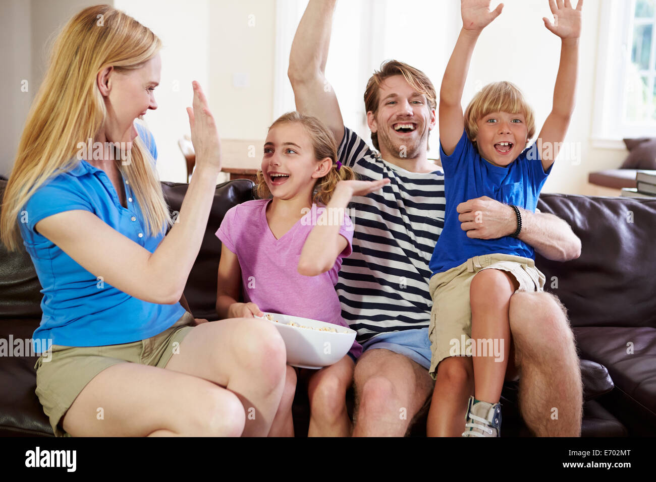 Famille regarder le soccer à la Télé Objectif célébrer Banque D'Images