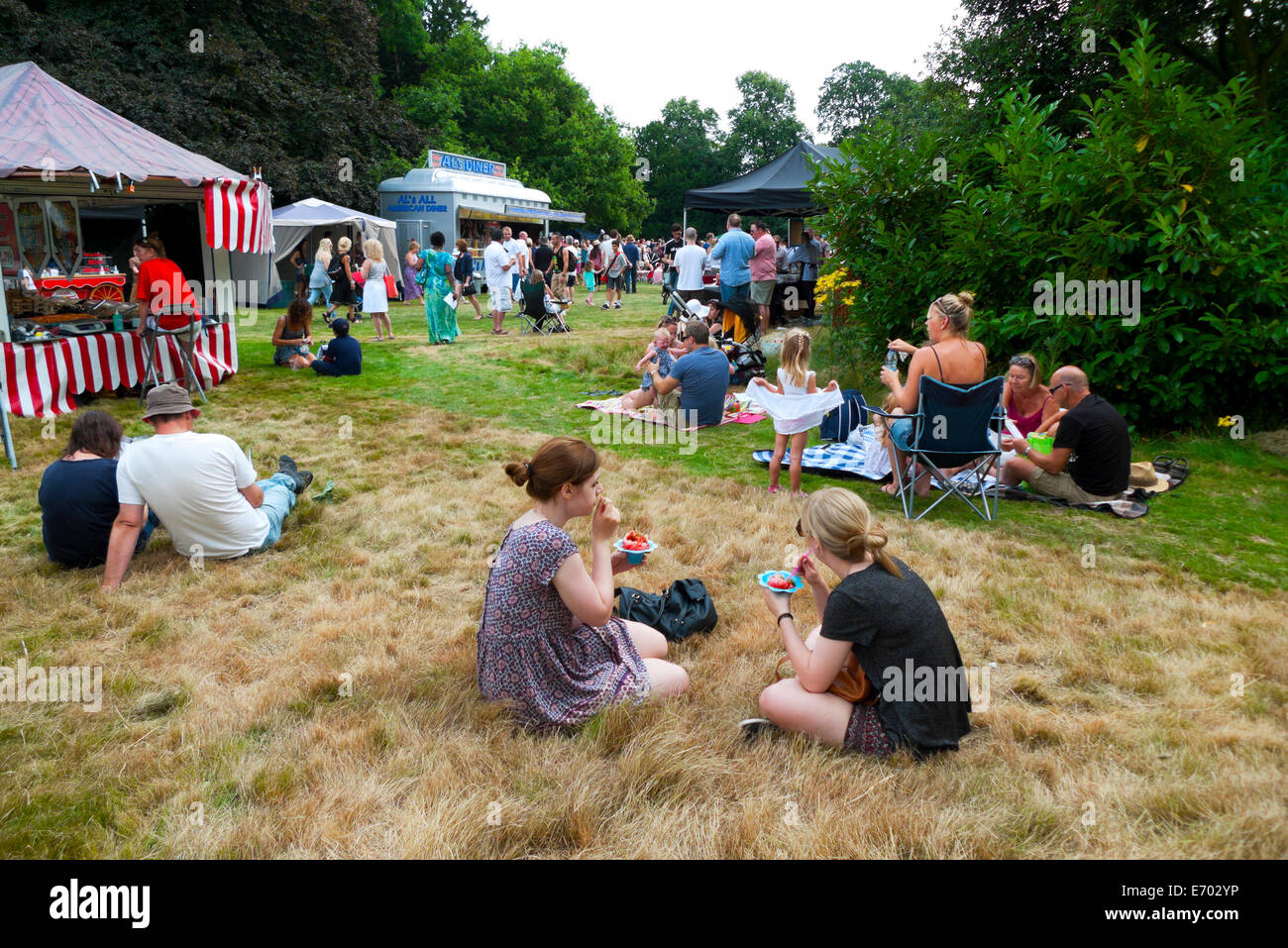 Les gens assis dans les jardins de Strawberry Hill House de manger des fraises à la foire d'été à Twickenham, London KATHY DEWITT Banque D'Images