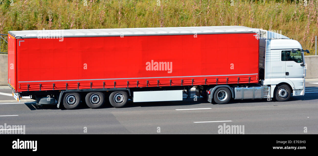 La logistique du transport par des camions poids lourds blanc propre & red soft verso chariot remorque rideau roulant le long de l'autoroute English UK Banque D'Images