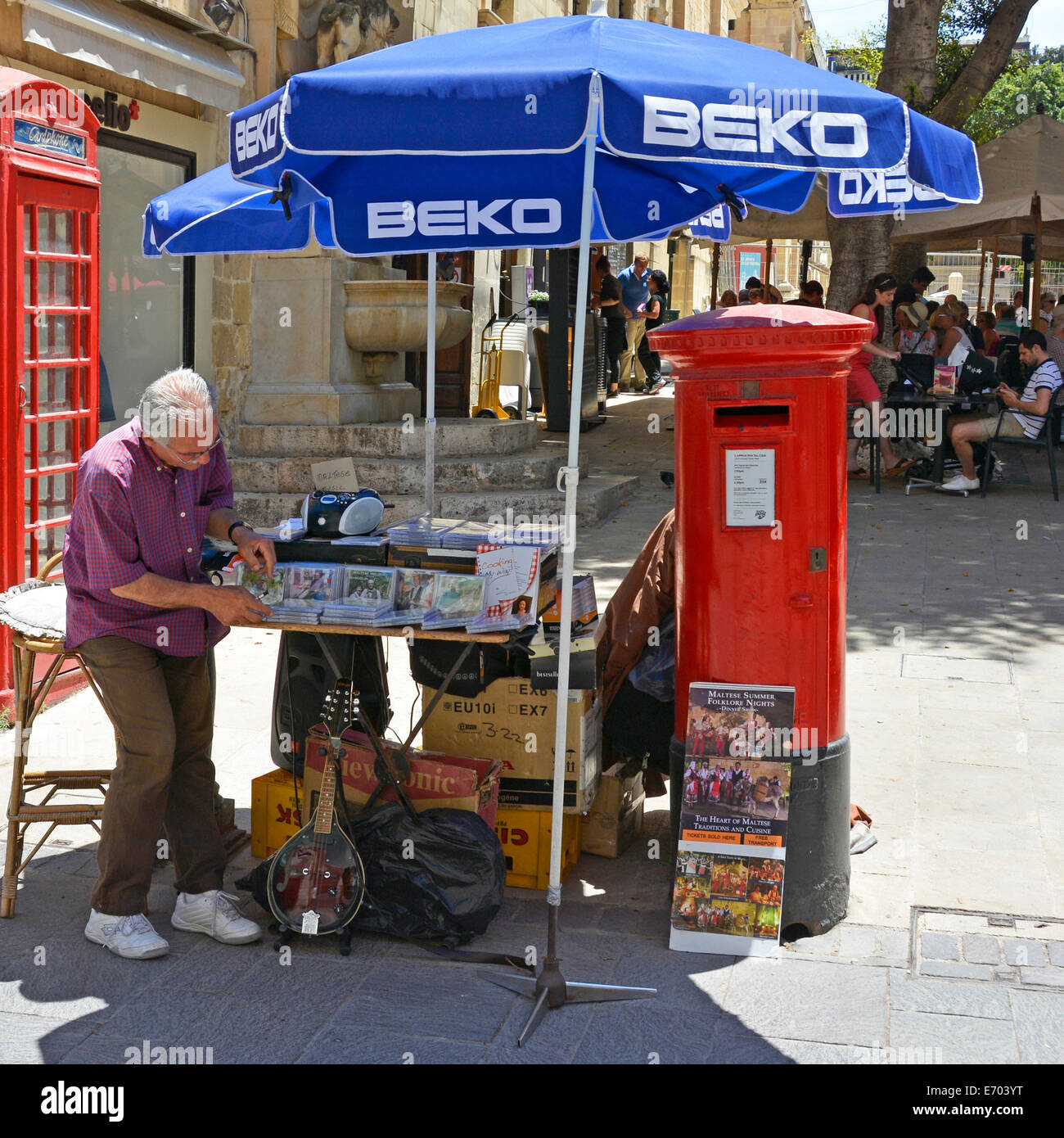 La valette centre-ville homme la configuration d'un petit décrochage de CDs sous les parasols à côté de red UK post box sur une chaude journée d'été la Rue de la République de Malte La Valette Banque D'Images