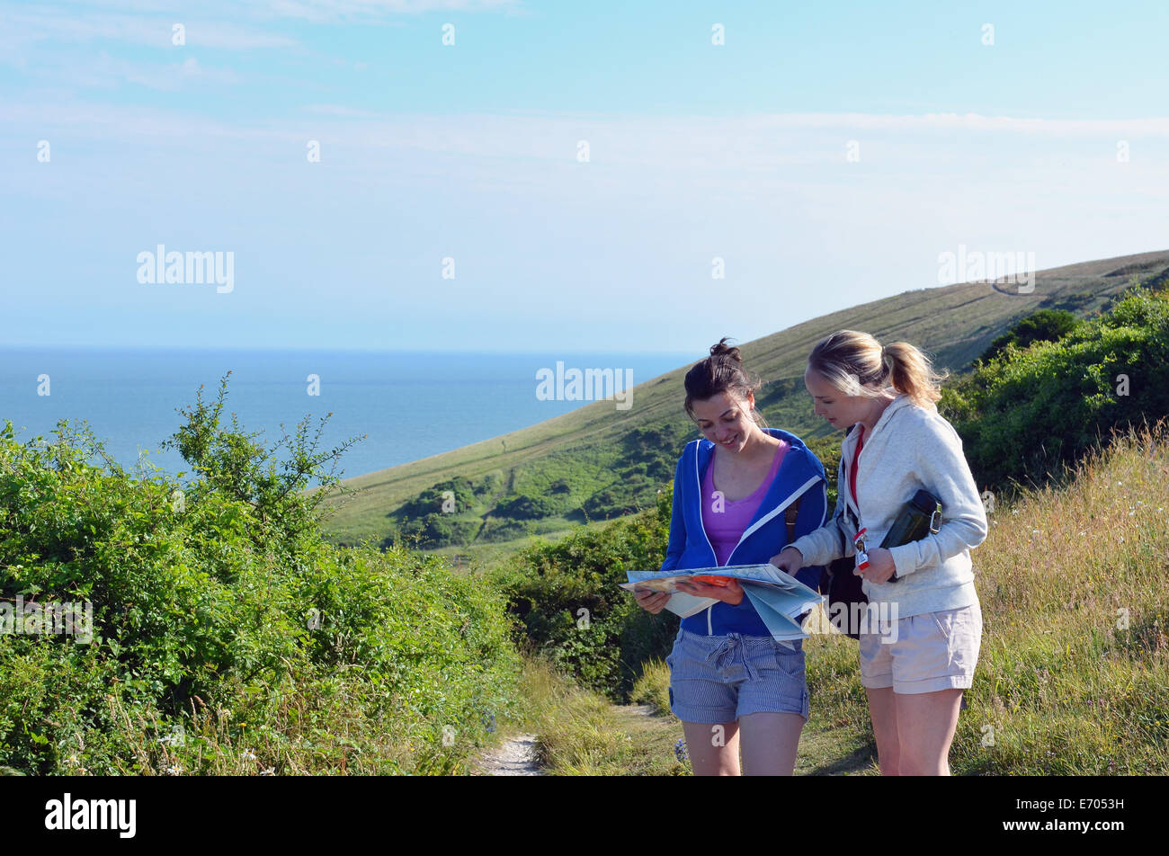 Deux jeunes femmes sur le sentier du littoral à la carte Banque D'Images Deux jeunes femmes sur le sentier du littoral à la carte Banque D'Images