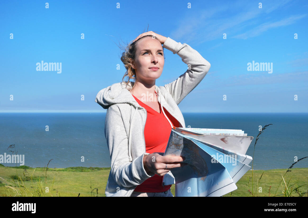 Jeune femme tenant une carte par mer Banque D'Images Jeune femme tenant une carte par mer Banque D'Images