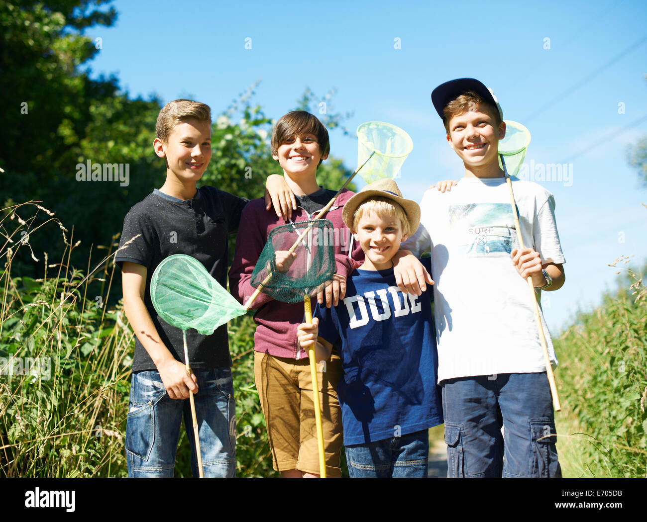 Portrait de quatre garçons avec des filets de pêche Banque D'Images