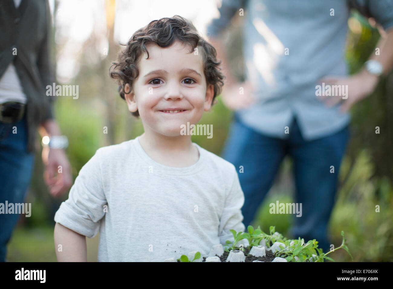 Portrait de jeune garçon avec des plantes en boîte à œufs in allotment Banque D'Images