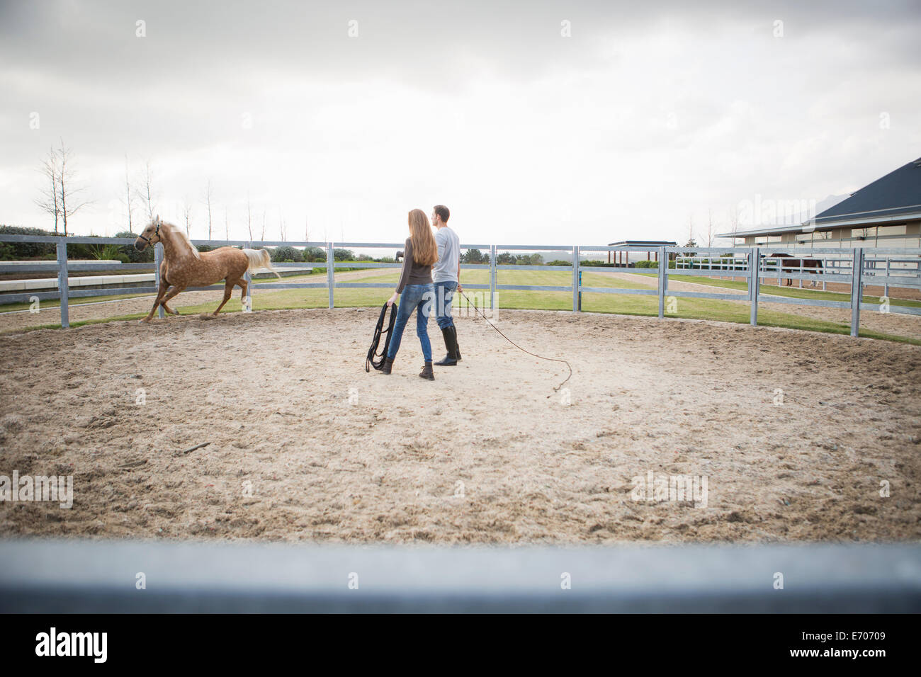 Deux formation stablehands horse en anneau paddock Banque D'Images