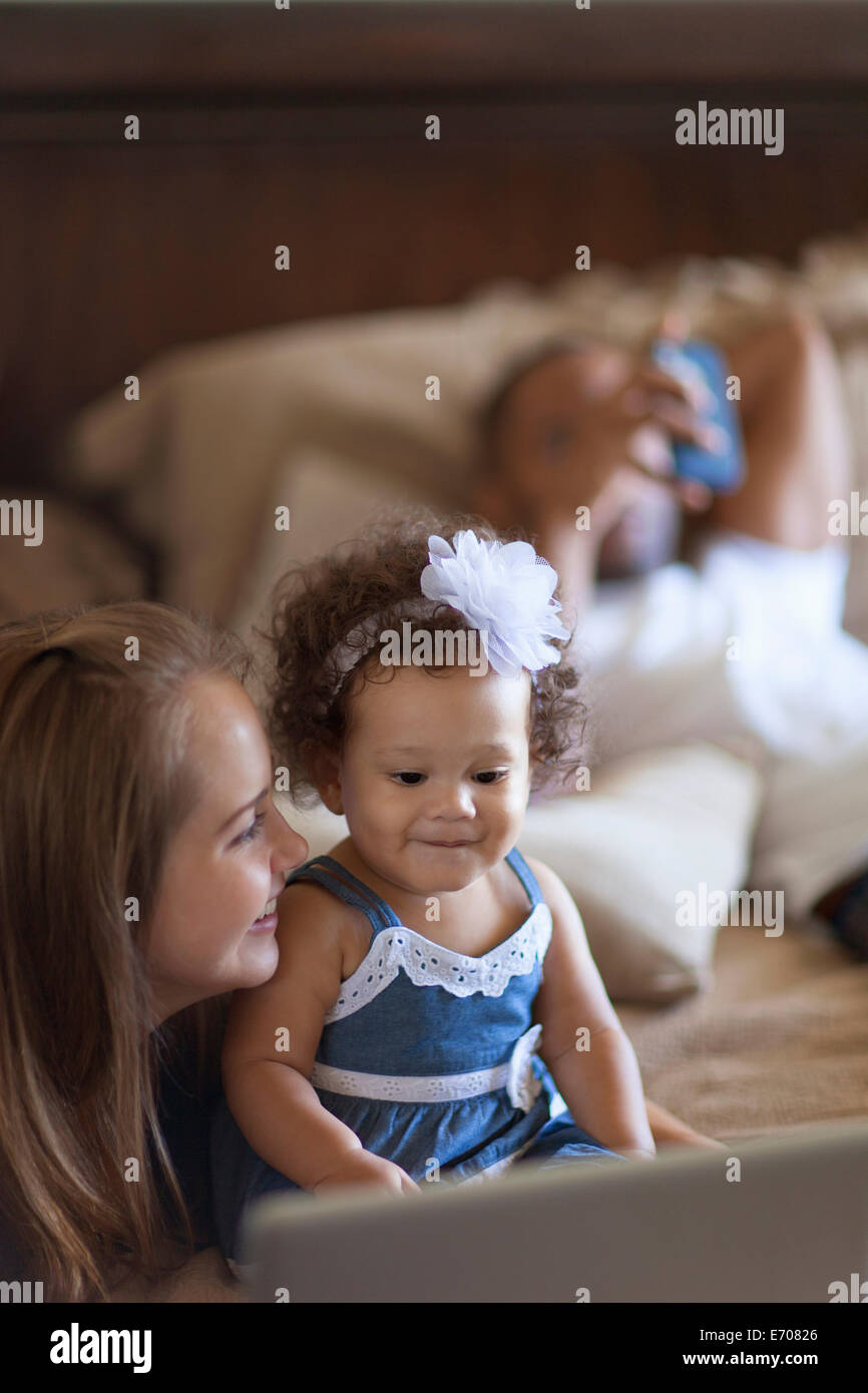 Bébé fille mère montrant un écran d'ordinateur portable Banque D'Images