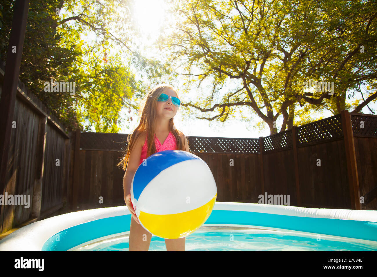 Girl holding beachball en bassin de jardin Banque D'Images