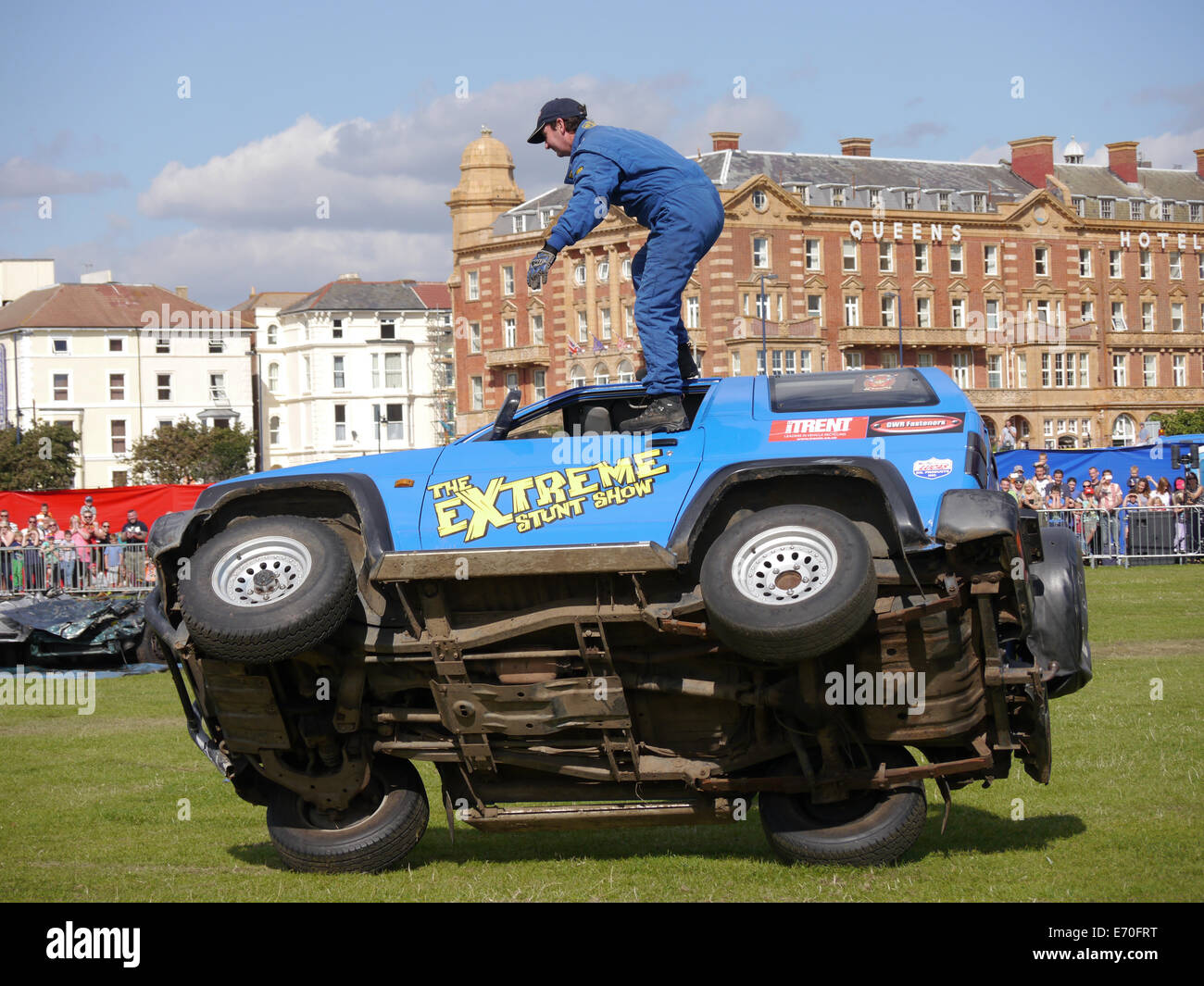 Un passager se dresse sur l'extérieur d'un véhicule qu'il entraîne sur deux roues à l'Extreme Stunt Show à Portsmouth, Angleterre Banque D'Images