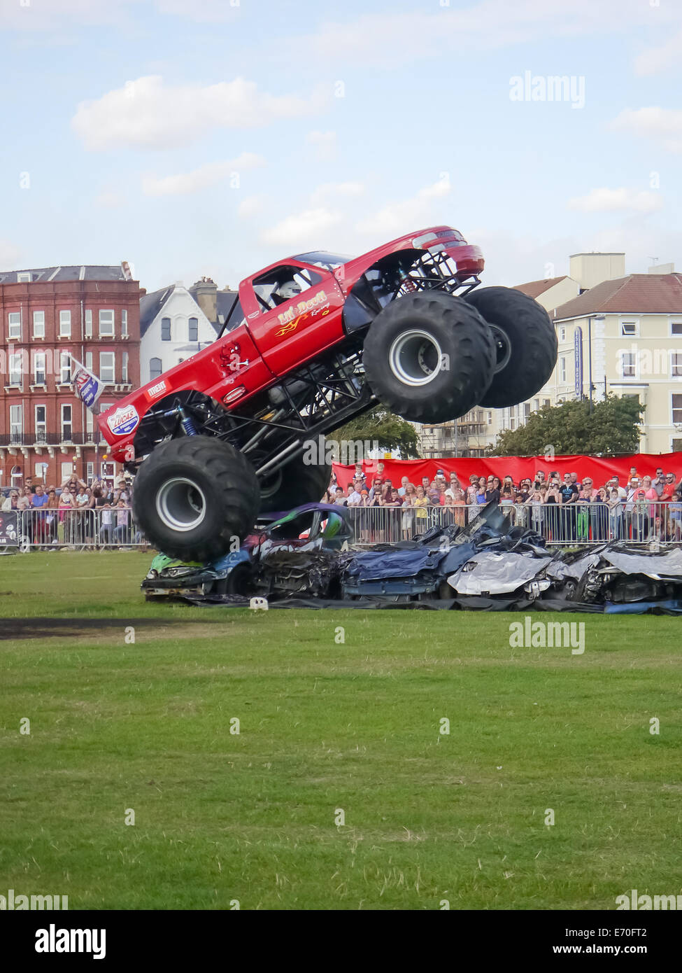 Le monster truck 'lil' devil' passe au-dessus de voitures et écrase au cours de l'Extreme Stunt Show à Portsmouth, Hampshire, Angleterre Banque D'Images