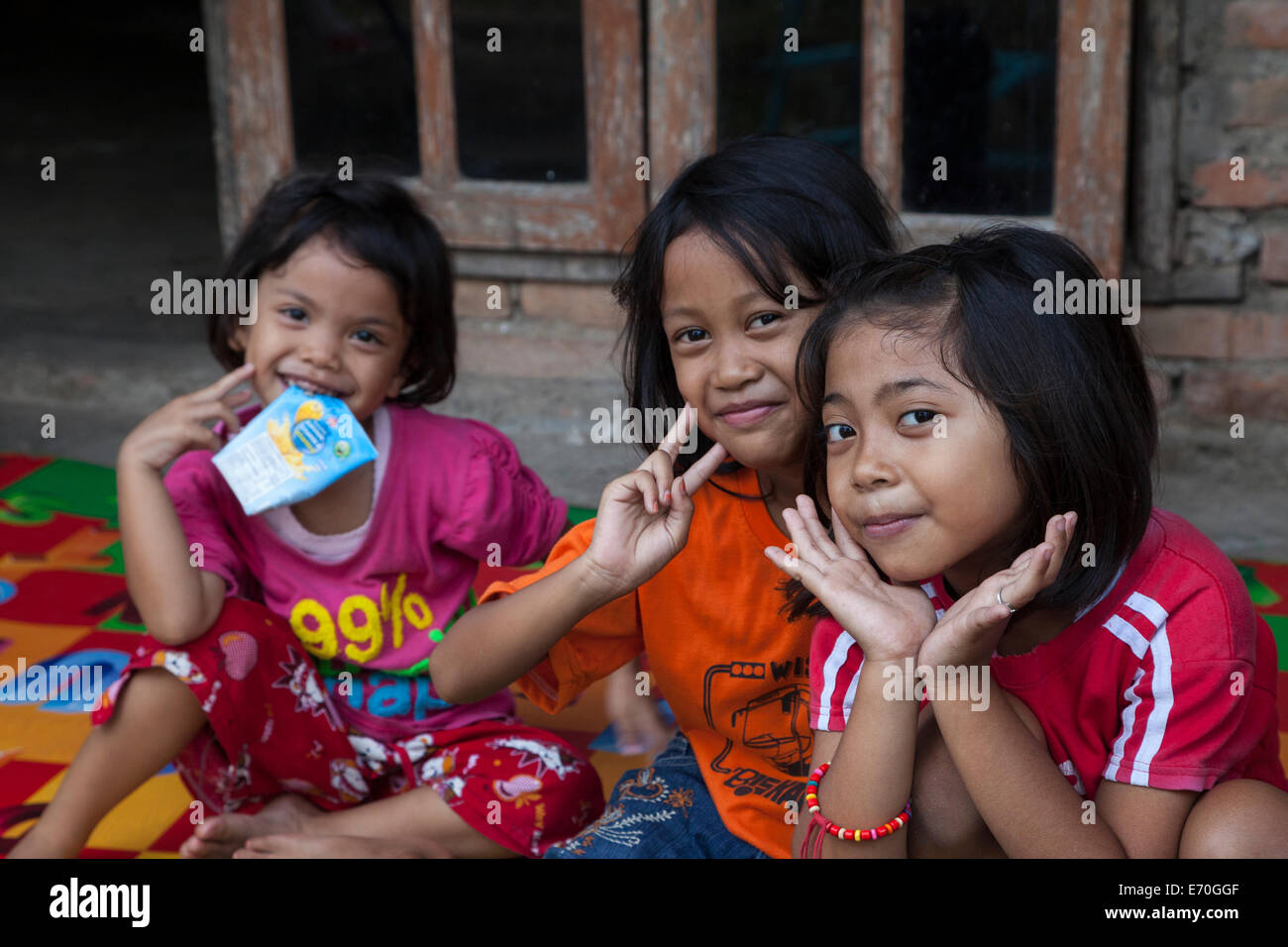 Borobudur, à Java, en Indonésie. Trois jeunes filles Javanais en face de leur village à la maison. Banque D'Images