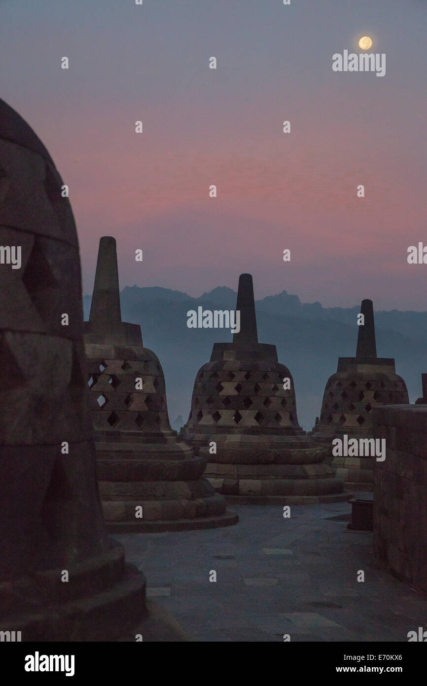 Borobudur, à Java, en Indonésie. Stupas et Pleine Lune juste avant le lever du soleil. Banque D'Images