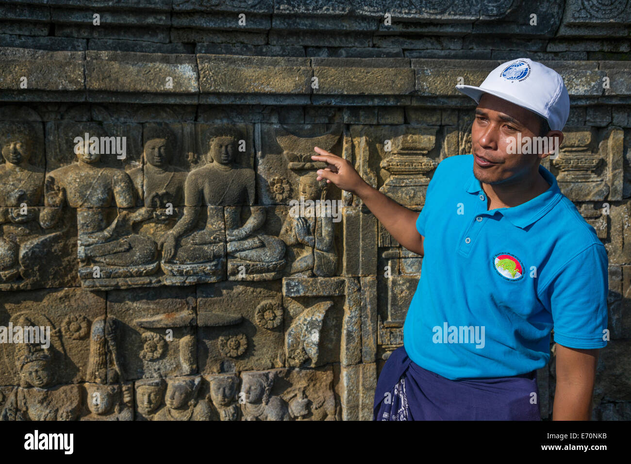 Borobudur, à Java, en Indonésie. Guide de l'Indonésie musulmane expliquant les mudras (gestes) Démontré par le Bouddha dans les sculptures murales. Banque D'Images