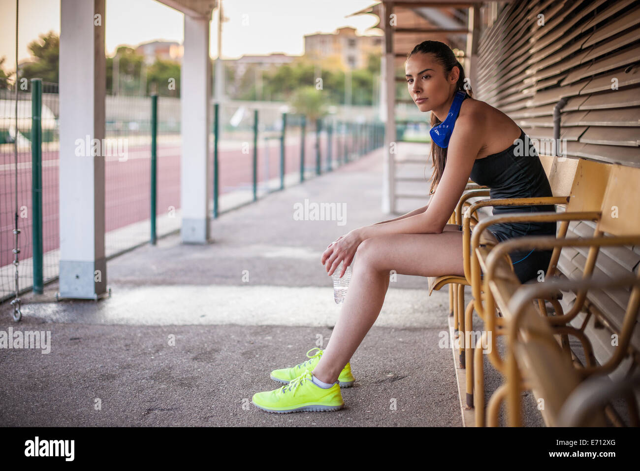 Jeune femme assise sur un banc, le repos Banque D'Images