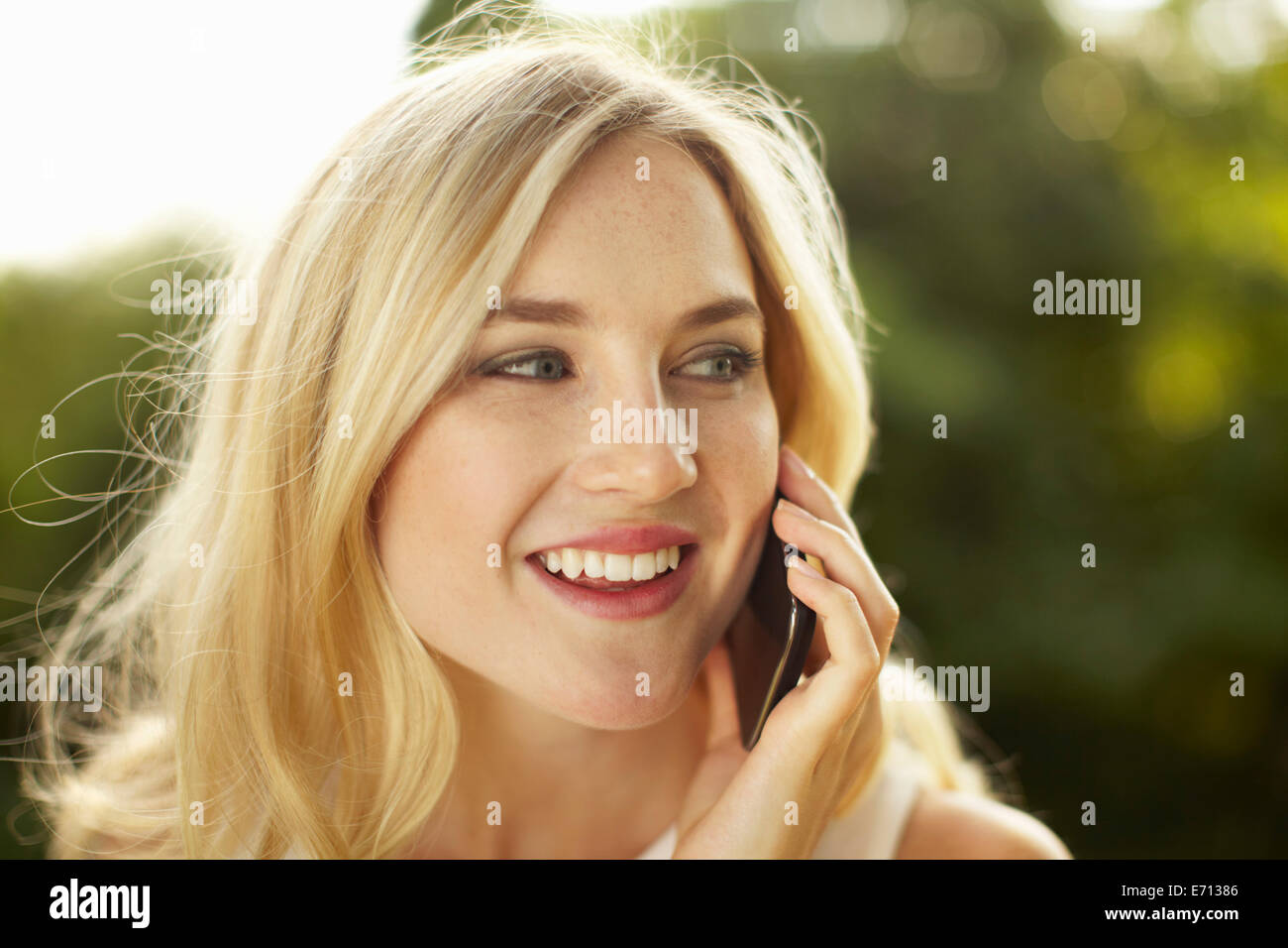 Young woman chatting on smartphone in park Banque D'Images