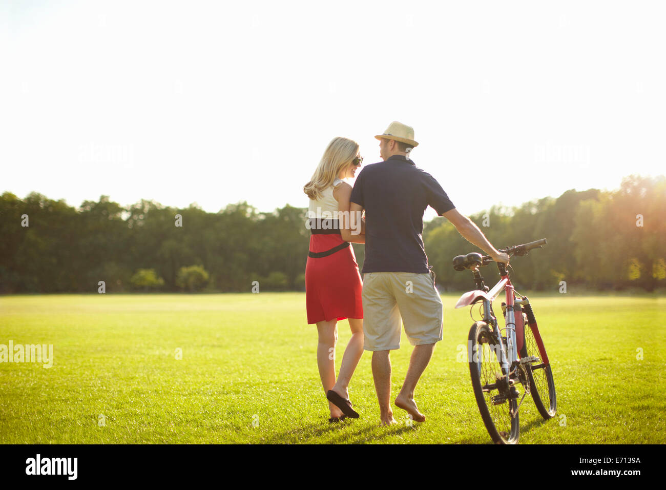 Couple poussant tout en flânant dans le parc à vélo Banque D'Images