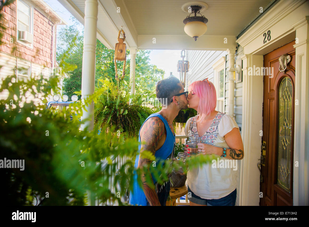 Funky couple kissing on porch Banque D'Images