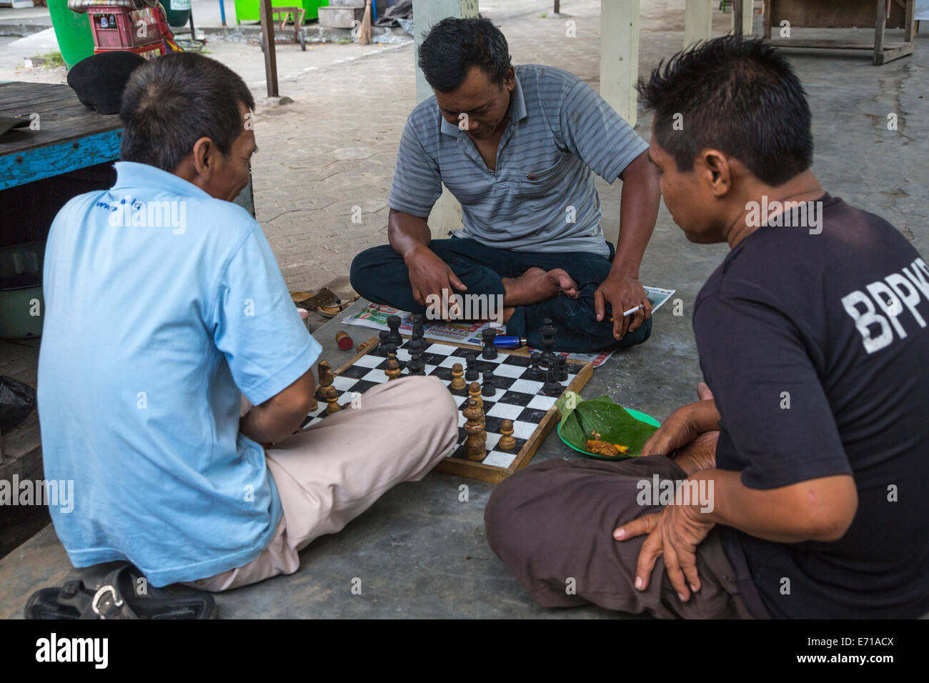 Yogyakarta, Java, Indonésie. Les hommes jouant aux échecs dans le Temple de Prambanan composé. Banque D'Images