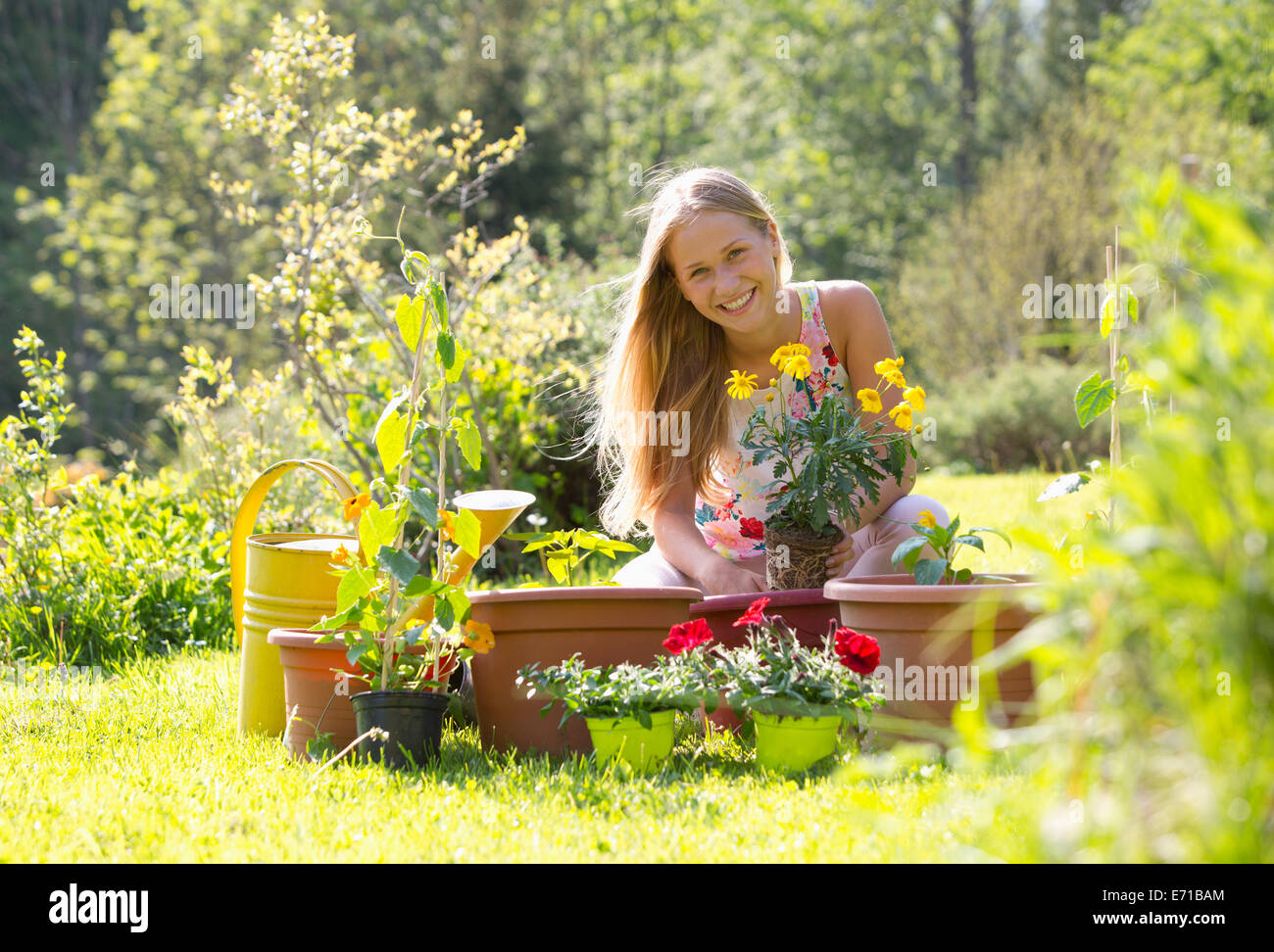 Portrait of smiling teenage girl rempotage des plantes dans le jardin Banque D'Images