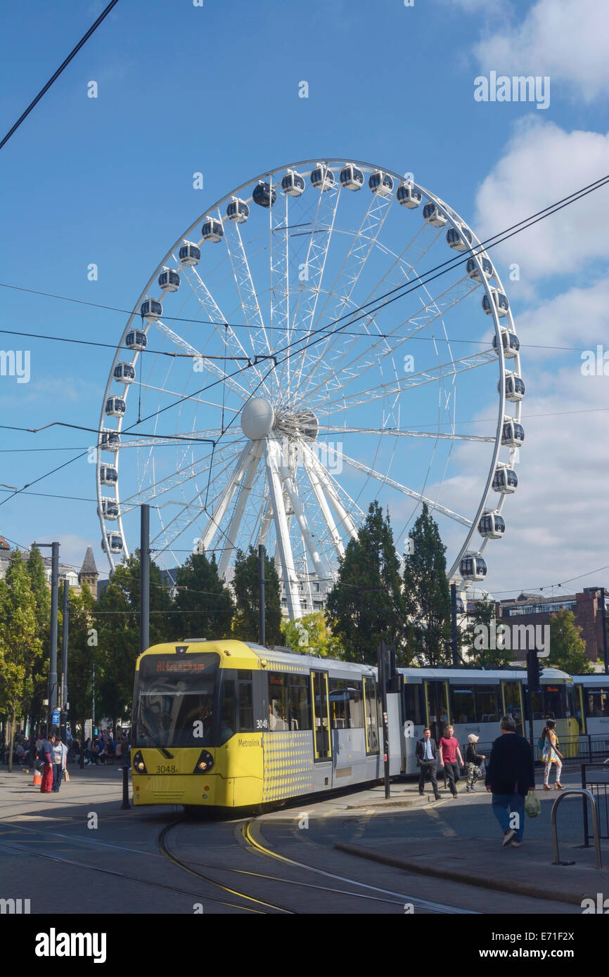 Tramway Metrolink passant par Piccadilly, Manchester, Manchester avec l'Œil dans l'arrière-plan. Banque D'Images