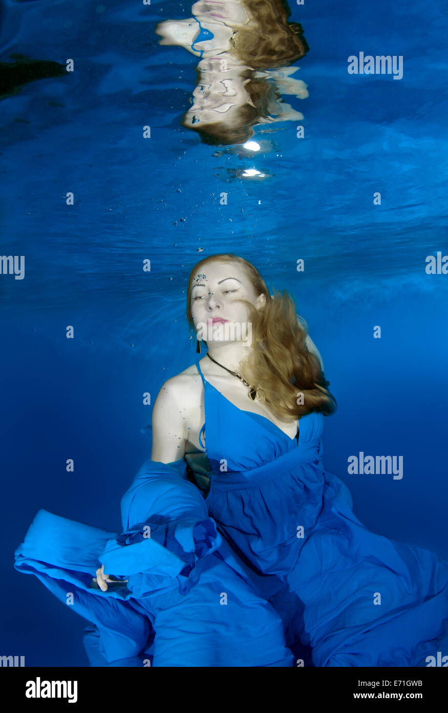 Une jeune femme avec de grands cheveux de poser dans un pool underwater Banque D'Images