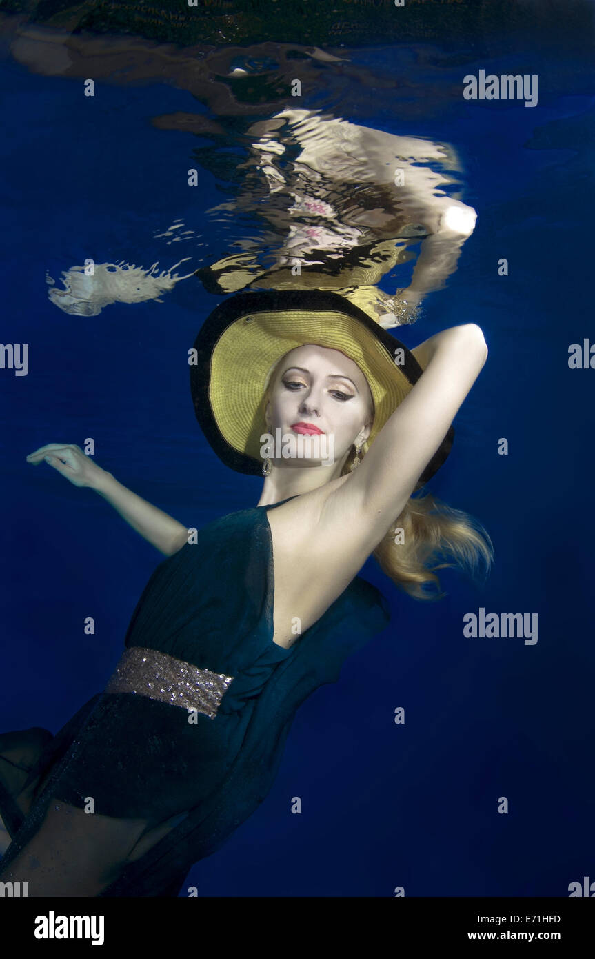 Une jeune femme avec de grands cheveux de poser dans un pool underwater Banque D'Images