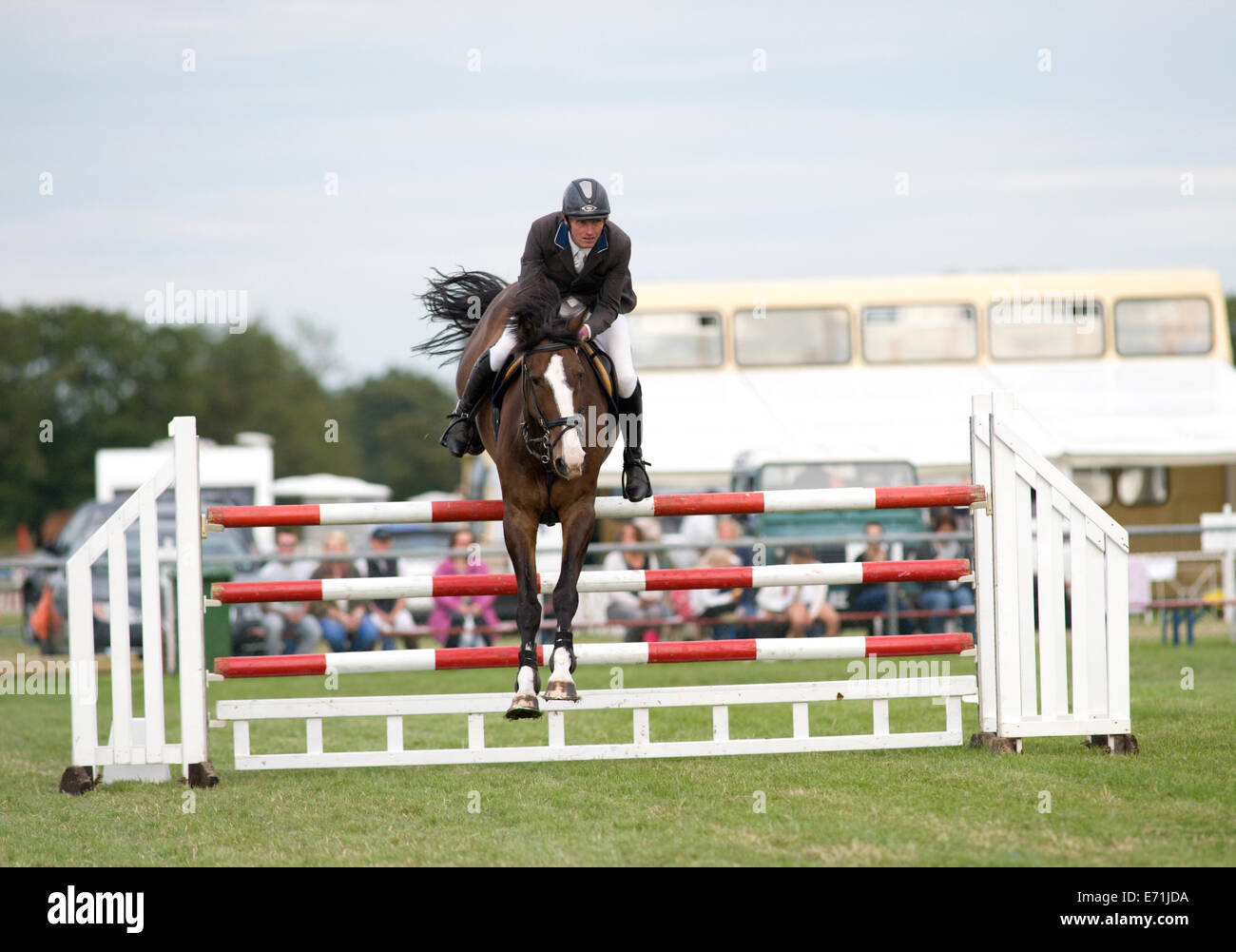 Un cheval et cavalier sauter une clôture dans le concours de saut à l'Edenbridge et salon de l'agriculture dans la région de Surrey Oxted Banque D'Images