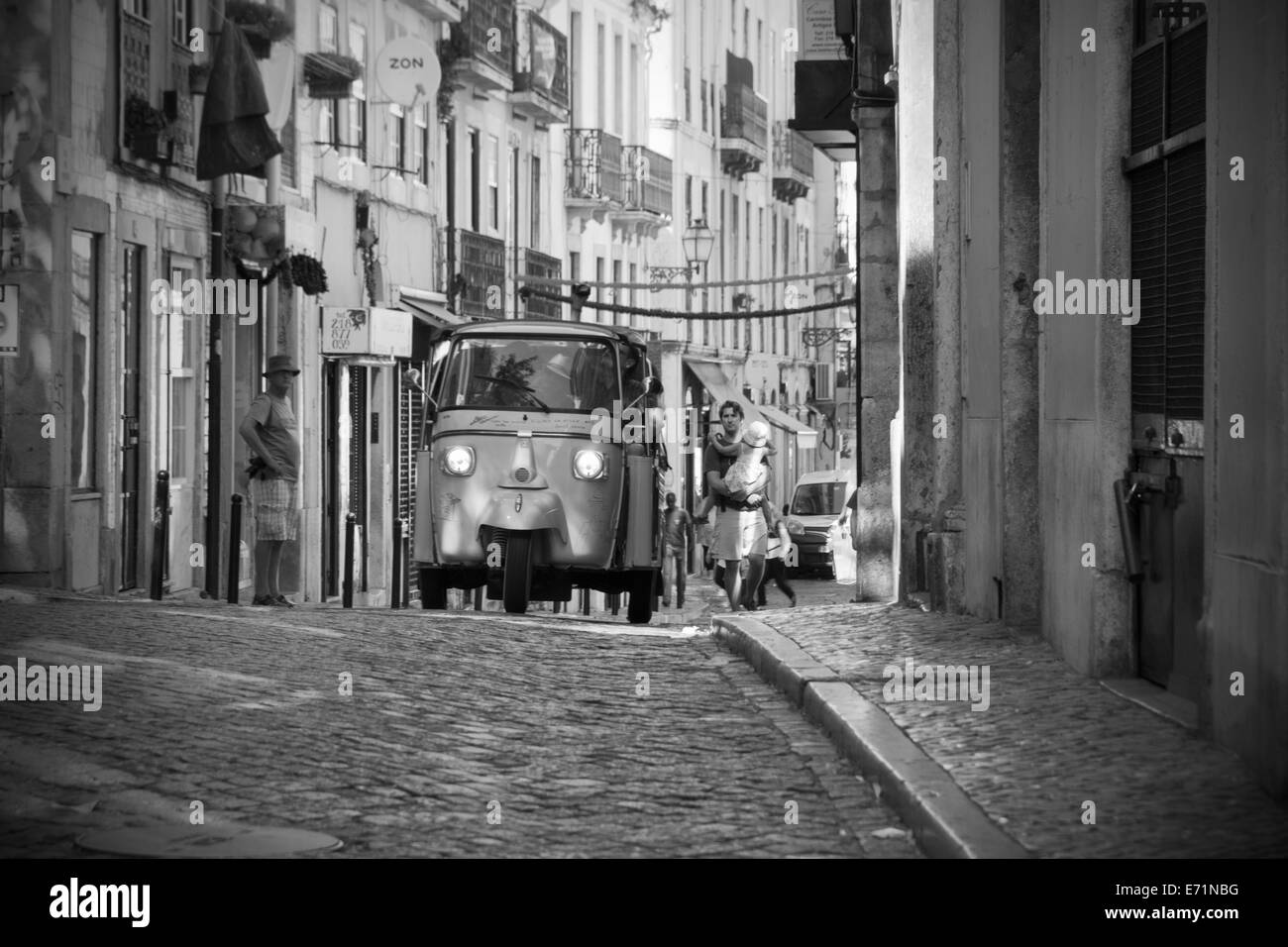 Un Tuktuk roulant dans les rues de l'Alfama, Lisbonne, Portugal Banque D'Images