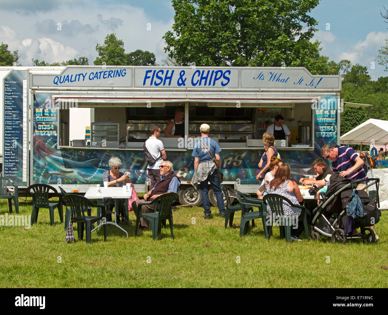 Diners, y compris les familles avec enfants, de manger à des tables,et de la file d'attente de clients à puce et poisson décroche à country fair Banque D'Images