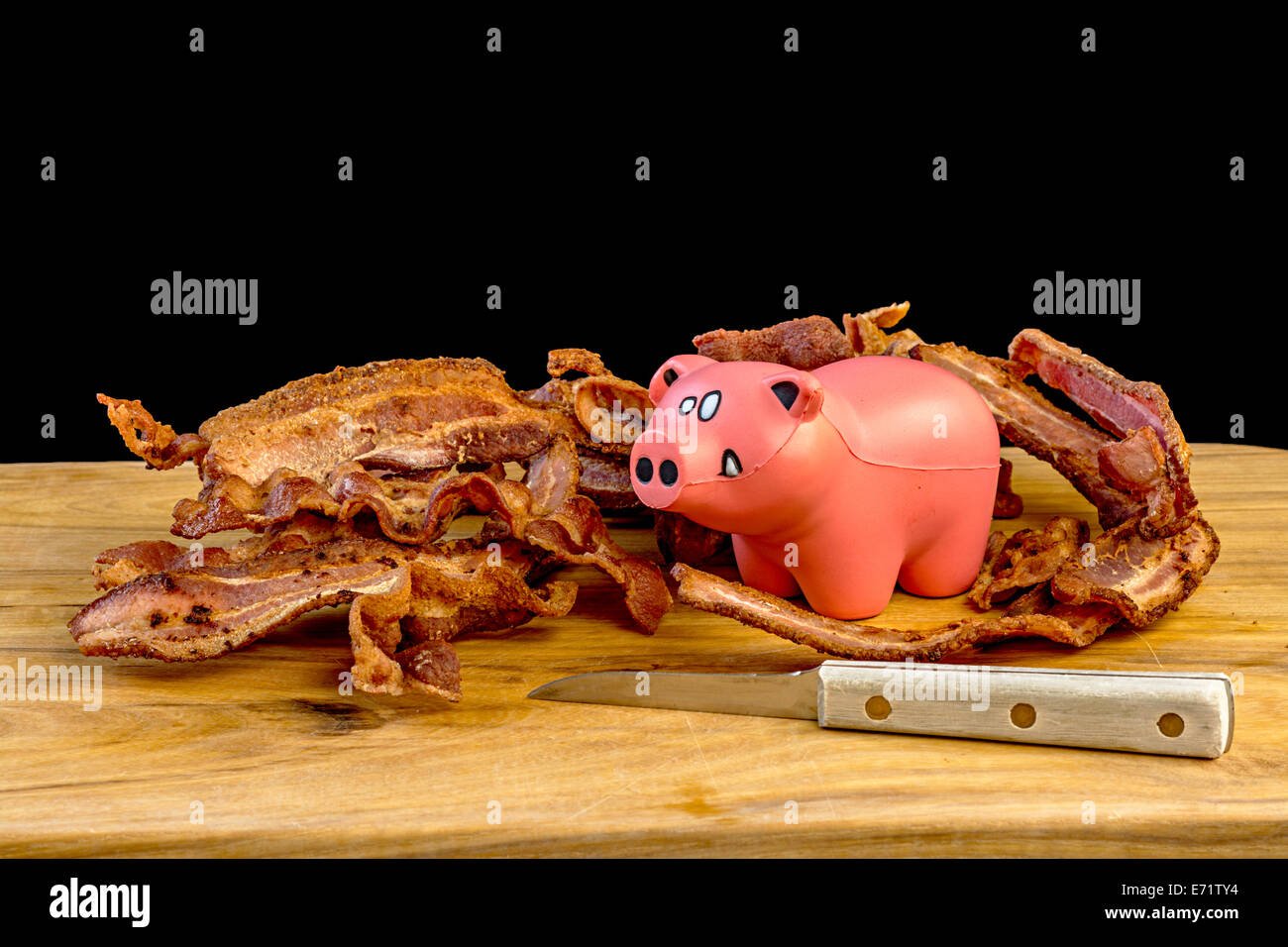 Cochon jouet avec du bacon cuit Banque D'Images