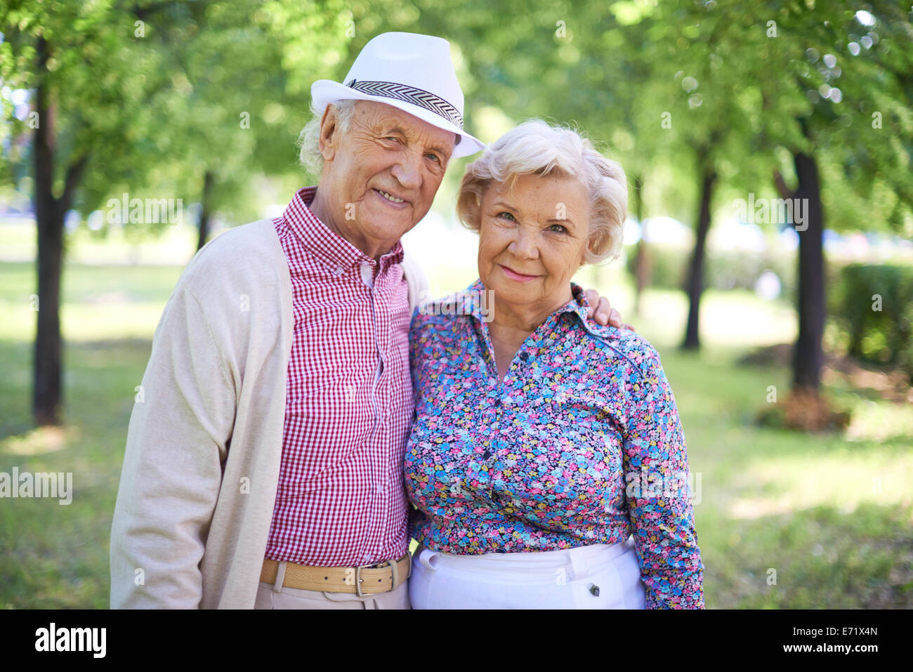 Couple de senior man and woman looking at camera dans le parc à l'été Banque D'Images