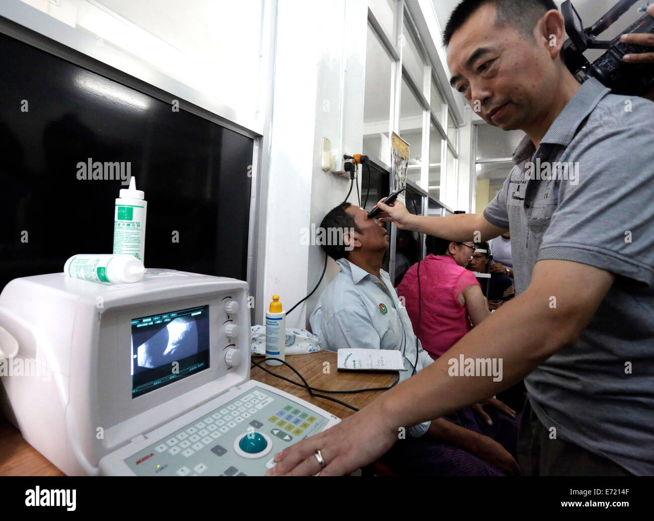 Yangon, Myanmar. 16Th Jun 2014. Un ophtalmologue chinois examine un patient à Yangon, Myanmar, le 4 septembre 2014. Une équipe médicale chinoise a commencé une campagne de traitement chirurgical de l'œil à Yangon jeudi que la troisième du genre de 'Action' de la luminosité dans le pays. Credit : U Aung/Xinhua/Alamy Live News Banque D'Images