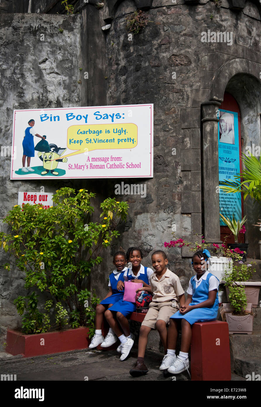 Saint Vincent et les Grenadines, Saint Vincent, Kingston, les enfants en dehors de l'école avec les ordures signe. Banque D'Images