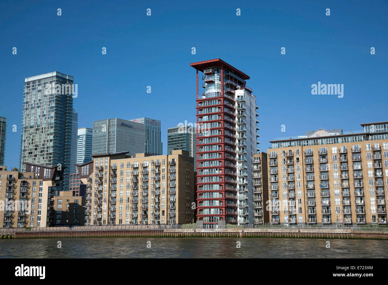 L'Angleterre, Londres, Isle of Dogs Thames riverside blocs avec Canary Wharf en arrière-plan. Banque D'Images