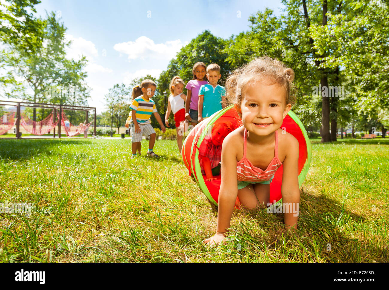 Cute groupe d'enfants jouer à ramper dans le tube. Banque D'Images