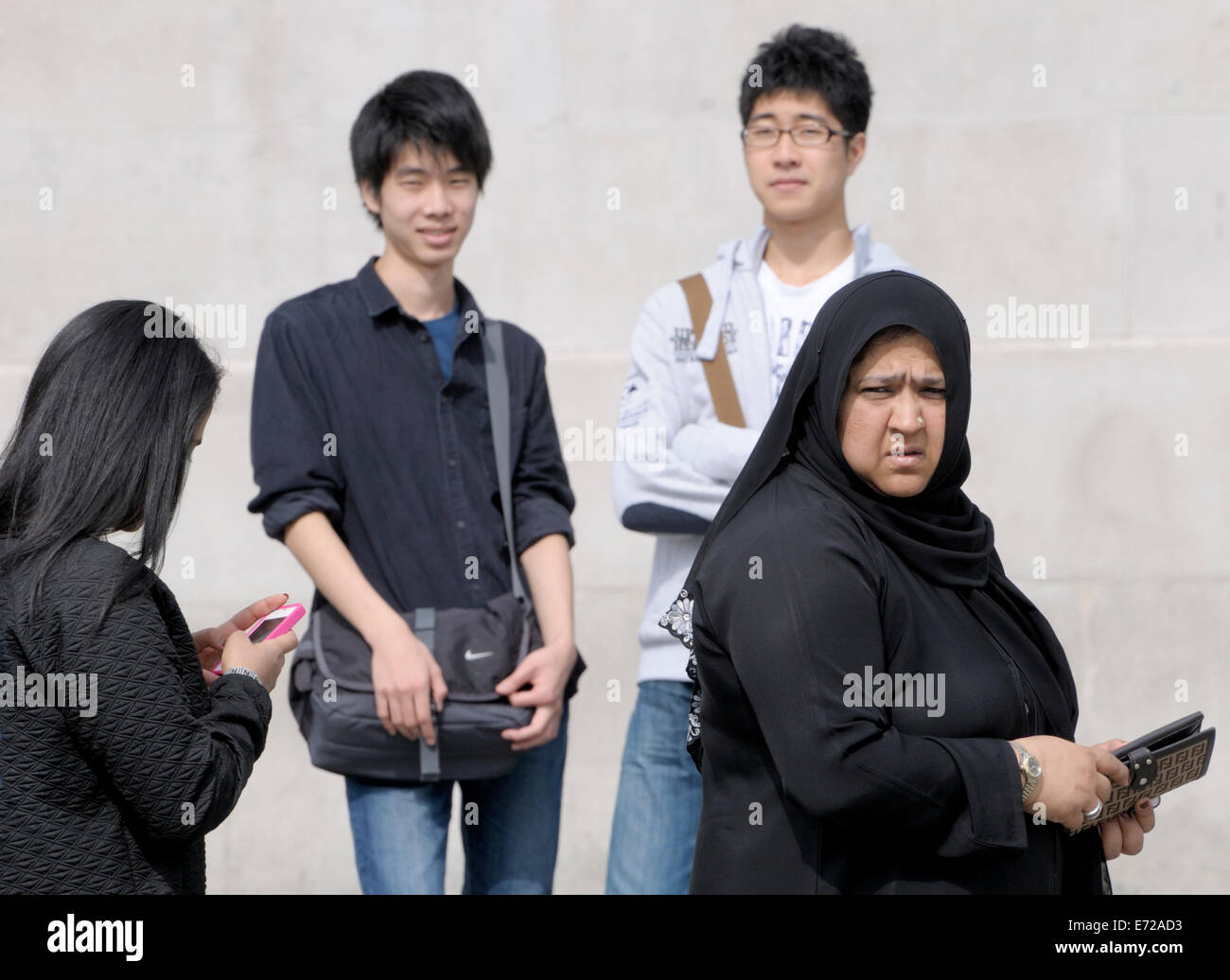 Londres, Angleterre, Royaume-Uni. Fotreign touristes regardant un artiste mime à Trafalgar Square Banque D'Images