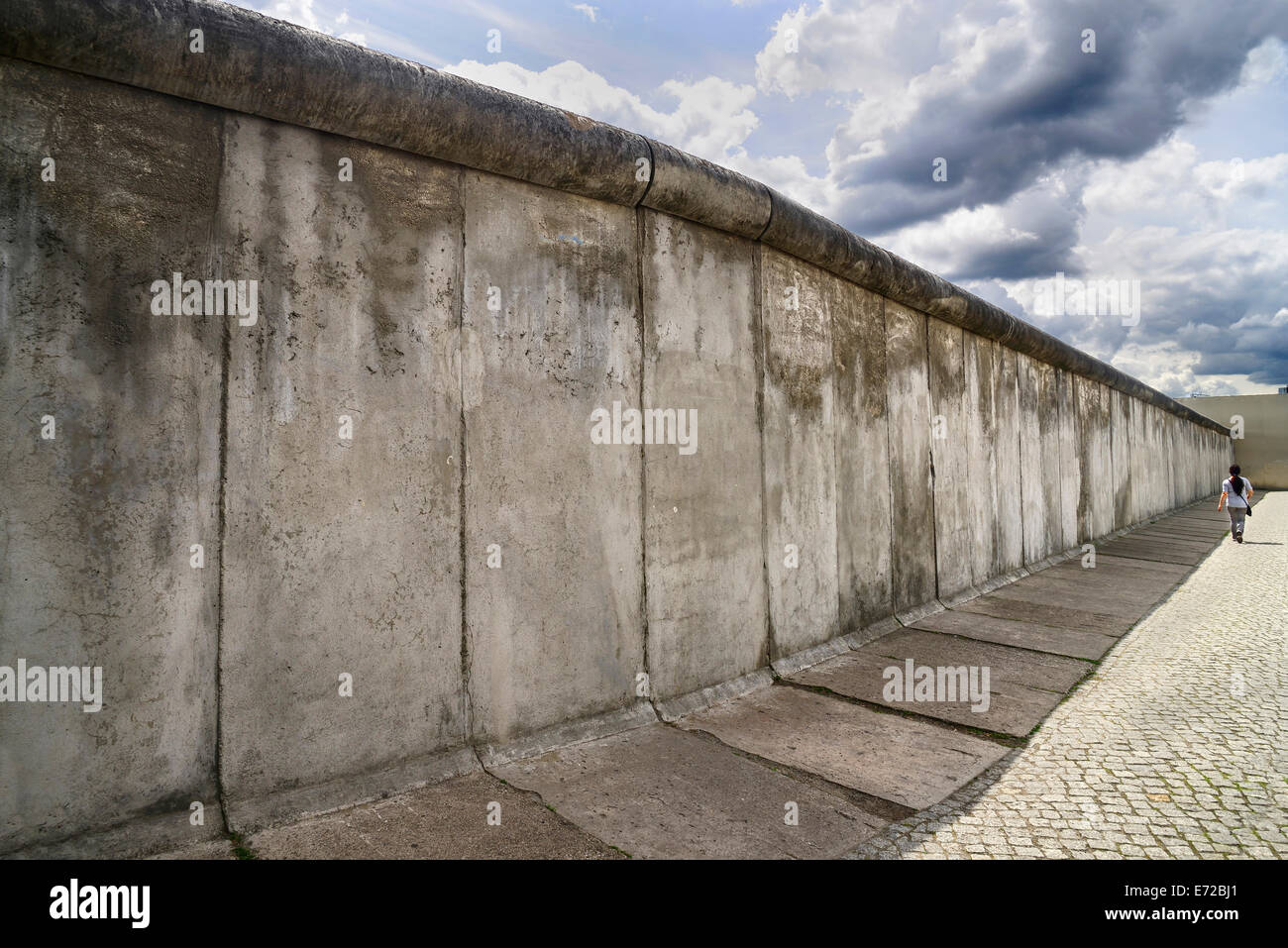 Allemagne, Berlin, Gedenkstatte Berliner Mauer, également connu sous le nom de Mémorial du Mur de Berlin Exposition au mémorial de la Bernauer Strasse contient le dernier morceau de mur de Berlin qui a conservé le motif de la bande frontalière affiche derrière elle. Banque D'Images