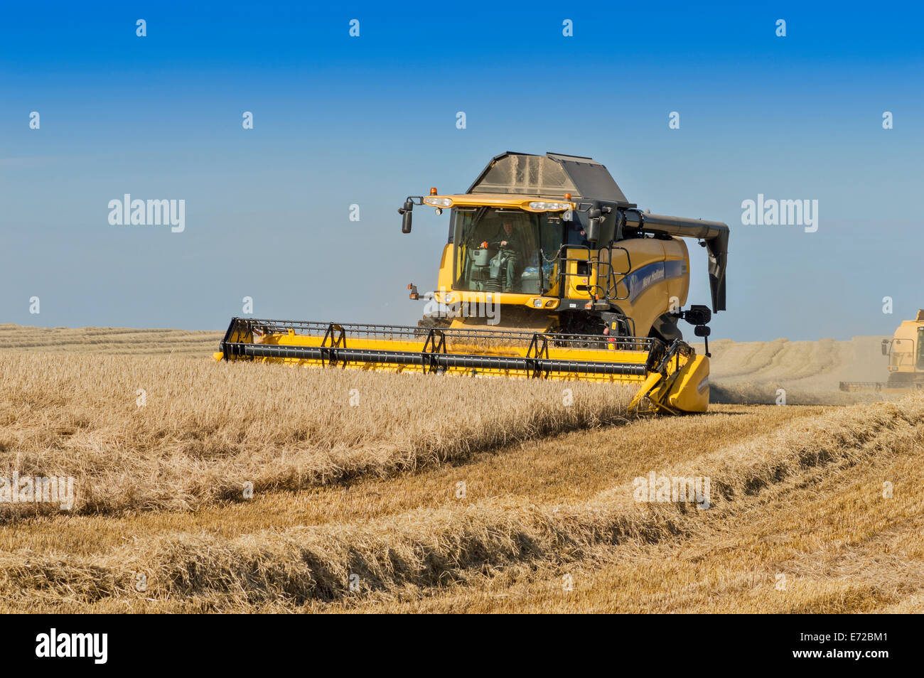 Moissonneuses-batteuses d'ABERDEENSHIRE ECOSSE COMPLÉTANT LA COUPE DANS UN CHAMP D'ORGE Banque D'Images