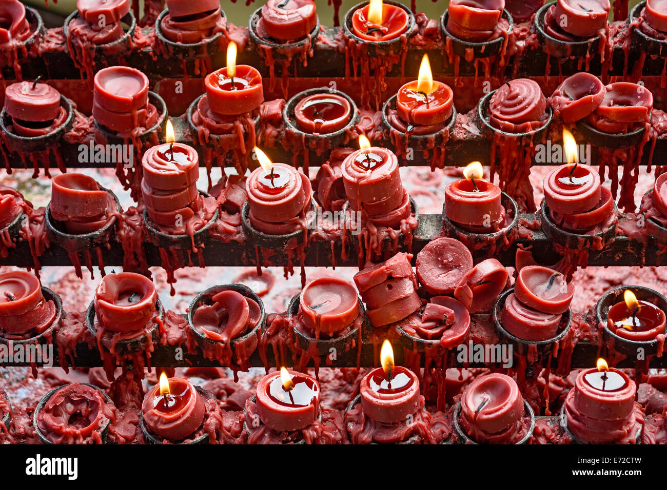 Allumé et éteint la bougie rouge peu d'offrandes de personnes pour leurs proches et requêtes de prières Banque D'Images