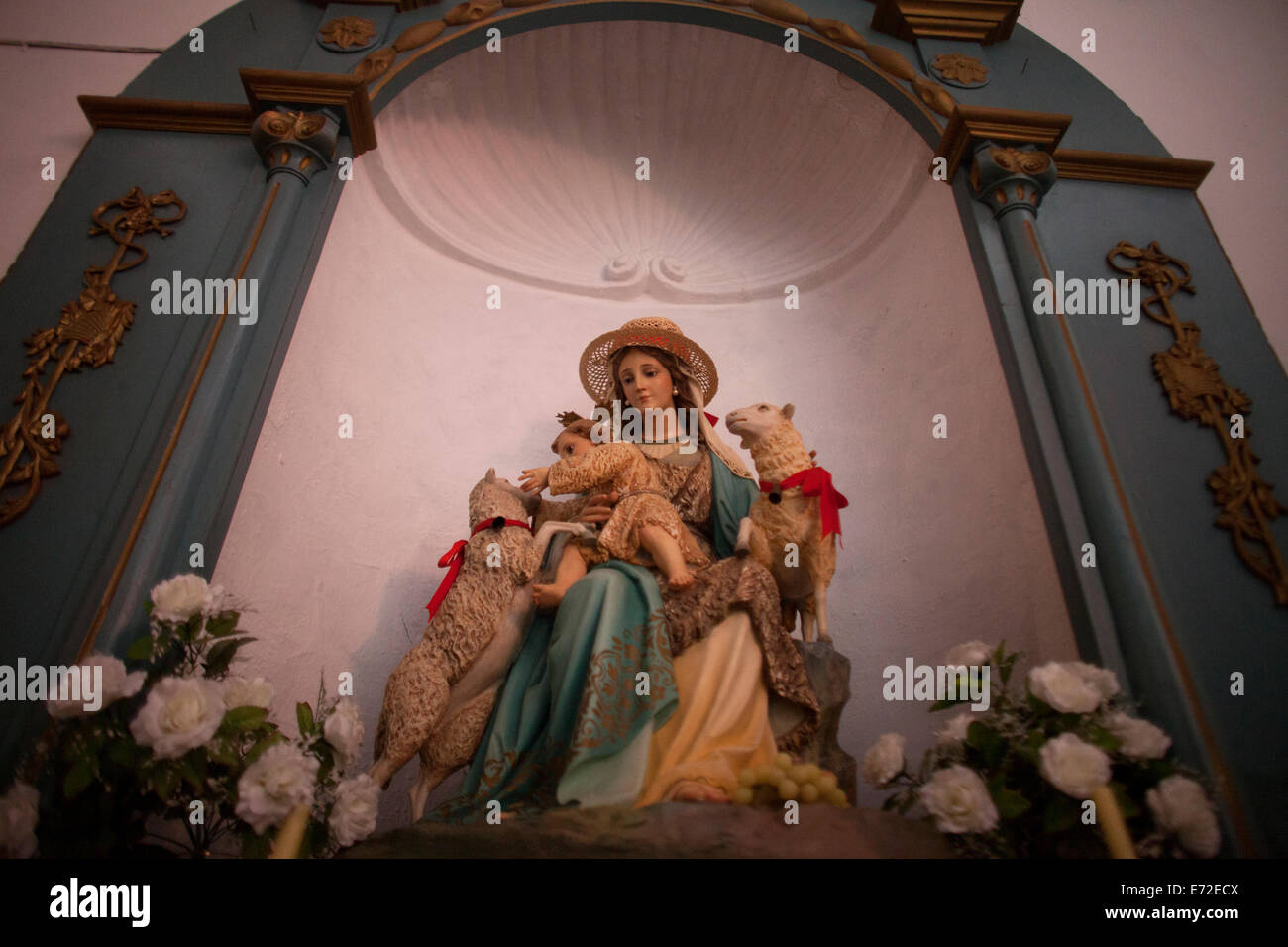 Une sculpture de la Vierge Marie vue comme la Divine Bergère, tenant un bébé Jésus jouant avec agneaux décore une église Banque D'Images